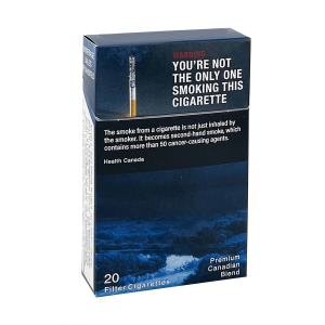 Pack of premium Canadian blend cigarettes with a bold health warning on a dark blue box: 'YOU'RE NOT THE ONLY ONE SMOKING THIS CIGARETTE' and additional warning text below.