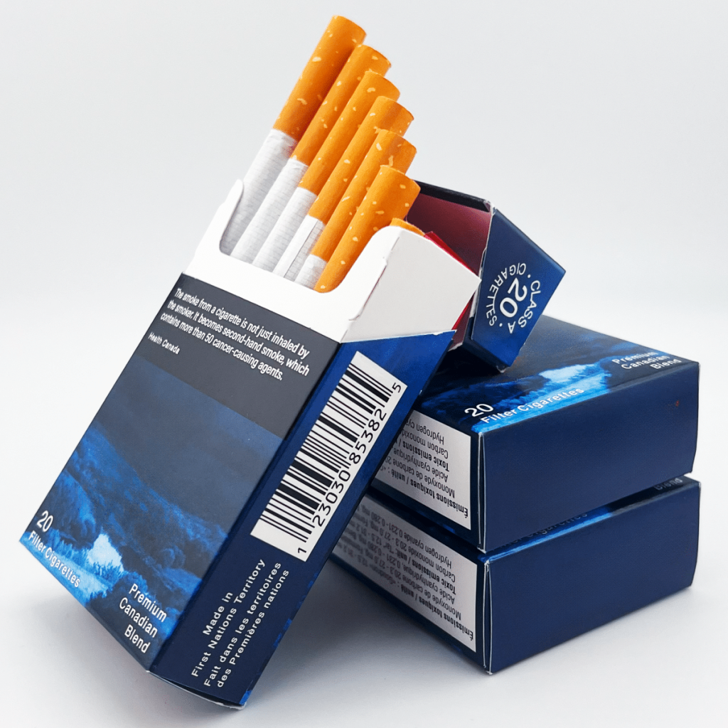 Open pack of Canadian Classics Original smokes on top of 2 more packs of the same brand, neutral white background